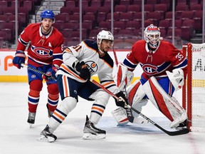 Evander Kane (91) of the Edmonton Oilers skates against Canadiens' Ben Chiarot (8) and goaltender Sam Montembeault during the first period at the Bell Centre on Saturday, Jan. 29, 2022, in Montreal.