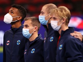 Montrealer Félix Auger Aliassime, far left, looks up as he stands with his team for the anthem before the first group C match during Day 2 of the 2022 ATP Cup tie between the United States and Canada at Qudos Bank Arena on Sunday, Jan. 2, 2022, in Sydney, Australia.