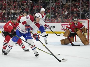 CHICAGO, ILLINOIS - JANUARY 13: Michael Pezzetta #55 of the Montreal Canadiens controls the puck against Riley Stillman #61 of the Chicago Blackhawks during the first period at United Center on January 13, 2022 in Chicago, Illinois.