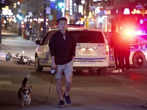 Jiayuan walks his dog Dex on Sainte-Catherine Street as Montreal police stop and check people travelling in pairs or groups after curfew on April 11, 2021.