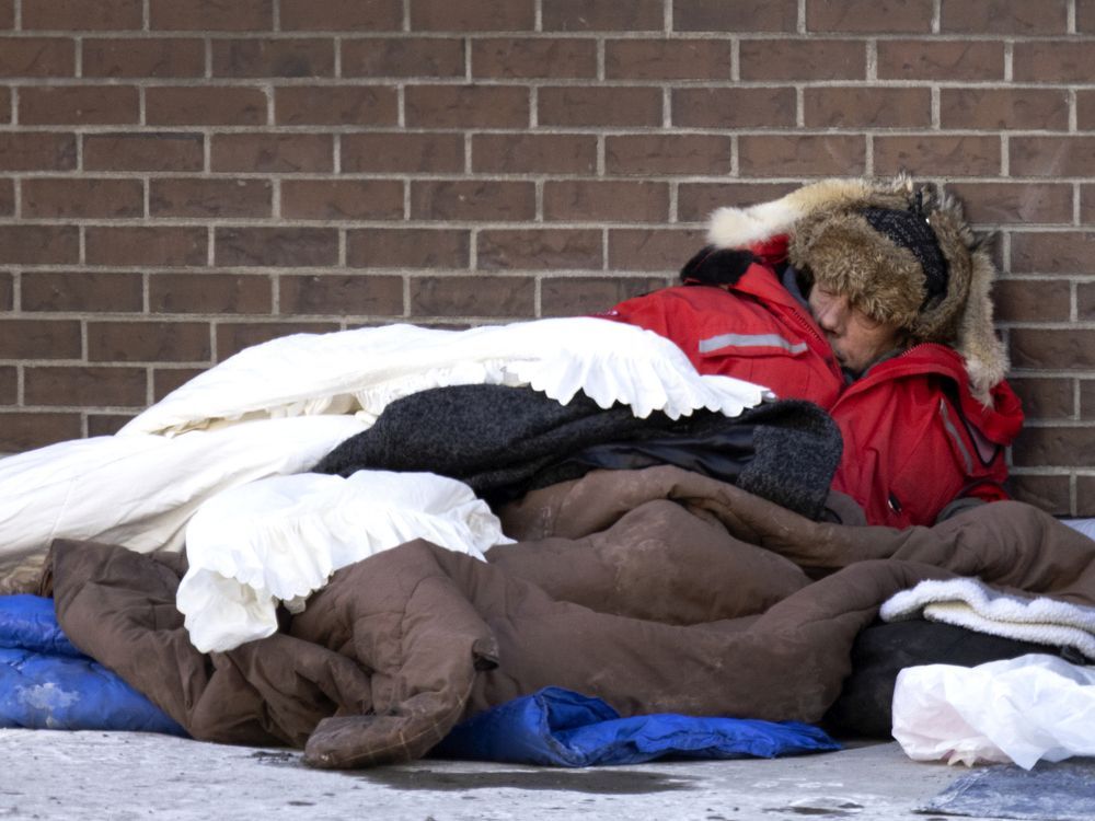 An unhoused man tries to stay warm on Jan. 16, 2022, as Montreal deals with a cold snap.
