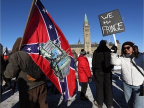A supporter carries an American Confederate flag during the Freedom Convoy protesting COVID-19 vaccine mandates and restrictions in front of Parliament on January 29, 2022 in Ottawa.