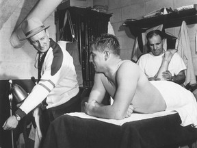 Twenty-one-year-old Jean Béliveau gets a rubdown and listens to Punch Imlach, his coach with the Quebec Aces of the Quebec Senior Hockey League, in this 1952 photograph.