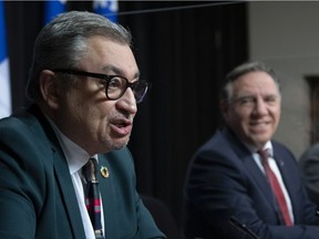 Horacio Arruda, Quebec director of National Public Health responds to reporters questions during a news conference on the COVID-19 pandemic, Tuesday, March 16, 2021 at the legislature in Quebec City. Quebec Premier Francois Legault, right, looks on.