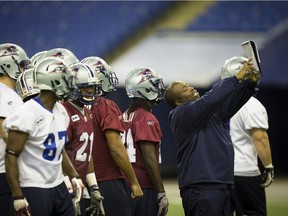 Montreal Alouettes defensive assistant Jean-Marc Edmé, right, goes over strategy with players during practice at the Olympic Stadium in Montreal on Nov. 14, 2012.