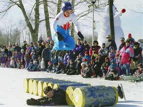Spectators watch as Patrick Leclerc leaps over nine barrels during winter-carnival festivities at Centennial Park in D.D.O. in January 1995. Lying amid the barrels is his trusting brother Sylvain.