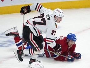 Montreal Canadiens' Laurent Dauphin is tripped by Chicago Blackhawks' Kirby Dach during first period NHL hockey action in Montreal Dec. 9, 2021.