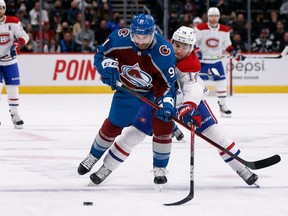 Colorado Avalanche centre Nazem Kadri (91) and Canadiens' Nick Suzuki (14) battle for the puck in the first period at Ball Arena on Saturday, Jan. 22, 2022, in Denver.