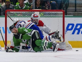 Dallas Stars' Joe Pavelski reacts to being checked as Montreal Canadiens' Alexander Romanov and goaltender Sam Montembeault defend during the third period at the American Airlines Center in Dallas on Jan. 18, 2022.