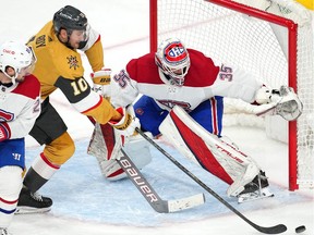 Montreal Canadiens goaltender Sam Montembeault (35) defends his net as Vegas Golden Knights centre Nicolas Roy (10) reaches for a deflected puck during the third period at T-Mobile Arena.