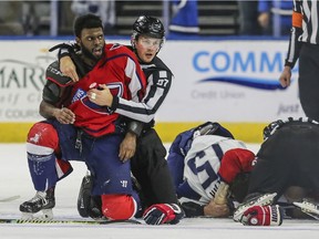 After an on-ice fight, South Carolina Stingrays defenceman Jordan Subban, left, is held by linesman Shane Gustafson while Jacksonville Icemen defenceman Jacob Panetta is face-down on the ice during overtime of an ECHL game in Jacksonville, Fla., on Saturday, Jan. 22, 2022.