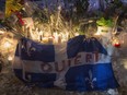A Quebec flag with the word "Open" written on it is shown in remembrance of six victims of a shooting at mosque during a vigil in Quebec City on Jan. 30, 2017.
