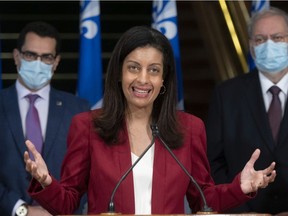 Quebec Liberal Leader Dominique Anglade gestures during a news conference on Thursday, December 9, 2021 at the legislature in Quebec City, with Monsef Derraji, left, and Pierre Arcand, right.