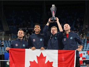 Canada's Steven Diez, Félix Auger-Aliassime, Denis Shapovalov and Brayden Schnur pose with the trophy and their national flag as they celebrate after winning the ATP Cup