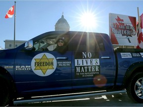 A person taking part in the "Freedom Convoy" rolls past the Manitoba Legislative Building in Winnipeg on Monday, Jan. 24, 2022.