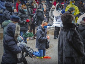 With churches closed, a man kneels during New Year's mass in the parking lot behind Mary Queen of the World Cathedral in Montreal Saturday, January 1, 2022.