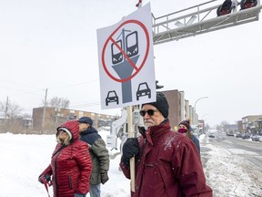 Neighbourhood resident Ronald Daignault holds a placard showing his opposition to the REM de l'Est during a media briefing by project planners CDPQ Infra at Georges-V and Dubuisson Aves. in east-end Montreal on Tuesday January 25, 2022.