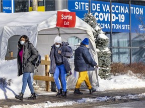 People exit a COVID-19 vaccination centre on Parc Ave. in Montreal on Friday, Jan. 28, 2022.