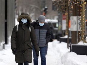 Pedestrians remain masked as they go about their day in downtown Montreal, on Friday, February 4, 2022.