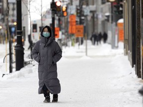 A woman keeps her mask on while walking in downtown Montreal, on Feb. 4, 2022.