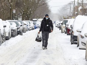 Mohammed Tewfik Saidi walks down the middle of Clark St. on a snowy day in Montreal's Mile End district February 4, 2022.