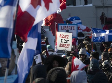 Signs carried along by protesters on Grande Allée next to Quebec's National Assembly during massive protest against COVID-19 vaccine and health restrictions on Saturday, Feb. 5, 2022.