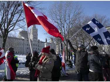 Protesters walk next to Quebec's National Assembly during a massive protest against COVID-19 vaccine and health restrictions on Saturday, Feb. 5, 2022.