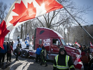 Truckers sit in front of Quebec's National Assembly during a massive protest against COVID-19 vaccine and health restrictions on Saturday, Feb. 5, 2022.