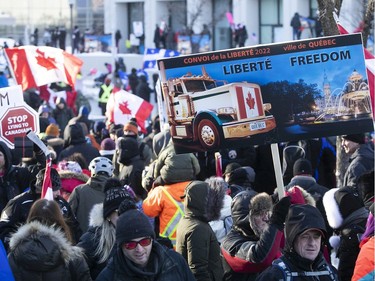 Signs carried along by protesters on Grande Allée next to Quebec's National Assembly during massive protest against COVID-19 vaccine and health restrictions on Saturday, Feb. 5, 2022.