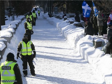 Quebec police officers on Grande Allee next to Quebec's National Assembly during a massive protest against COVID-19 vaccine and health restrictions on Saturday, Feb. 5, 2022.