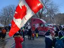 Des manifestants agitent des drapeaux canadiens et québécois lors d'un rassemblement devant l'Assemblée nationale pour protester contre les restrictions sanitaires liées à la COVID-19 à Québec le 5 février 2022.