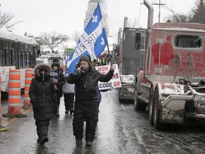 Protesters walk near the National Assembly on the second day of marches to protest against COVID-19 vaccine and health restrictions in Quebec, on Feb. 6, 2022.