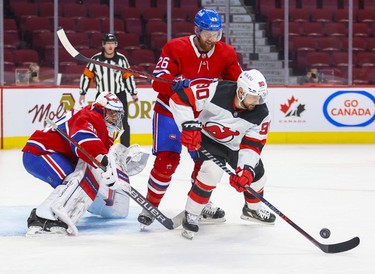 Montreal Canadiens' defenceman Jeff Petry leans on former team-mate New Jersey Devils' Tomas Tatar in front of goalie Cayden Primeau during second period in Montreal Tuesday, Feb. 8, 2022.