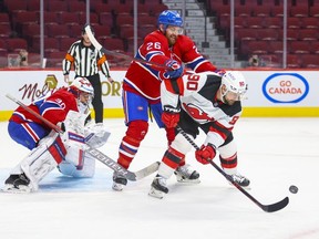 Montreal Canadiens' defenceman Jeff Petry leans on former teammate New Jersey Devils' Tomas Tatar in front of goalie Cayden Primeau during second period in Montreal Tuesday, Feb. 8, 2022.