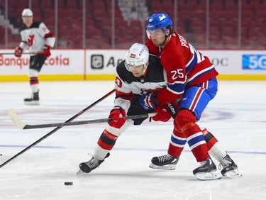 Montreal Canadiens' Ryan Poehling forechecks New Jersey Devils' Michael McLeod during first period in Montreal Tuesday, Feb. 8, 2022.