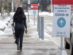 A woman leaves the COVID-19 vaccination clinic in the Saint-Laurent borough of Montreal Wednesday February 9, 2022.