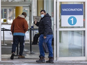 A man gives a photographer the thumbs up as he enters a COVID-19 vaccination clinic in the Saint-Laurent borough of Montreal on Wednesday, February 9, 2022.