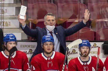 Montreal Canadiens interim head coach Martin St. Louis questions a referee's call during third period against the Washington Capitals in Montreal Thursday, Feb. 10, 2022. Players on bench are Josh Anderson, left, Jake Evans and Paul Byron.
