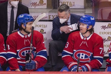 Montreal Canadiens interim head coach Martin St. Louis speaks to Jake Evans, left, and Tyler Toffoli on the bench during the first period against the Washington Capitals in Montreal Thursday, Feb. 10, 2022.