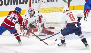 Montreal Canadiens' Cole Caufield takes a swing at a rebound next to Washington Capitals' Dimitry Orlov, in front of goalie Ilya Samsonov during the first period against the Washington Capitals in Montreal Thursday, Feb. 10, 2022.