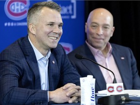 Montreal Canadiens general manager Kent Hughes, right, listens as interim head coach Martin St. Louis speaks during a press conference in Montreal on Thursday, Feb. 10, 2022.