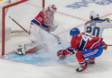 St. Louis Blues left wing Brandon Saad (20) sprays snow onto Montreal Canadiens goaltender Sam Montembeault (35) with Montreal Canadiens centre Laurent Dauphin (45) looking for the puck during second period in Montreal on Thursday, Feb. 17, 2022.