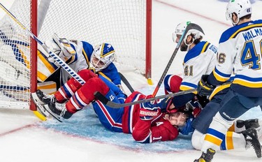 Montreal Canadiens right wing Brendan Gallagher (11) collides with St. Louis Blues goaltender Ville Husso (35) while being checked by defenseman Robert Bortuzzo (41) during first period against the St. Louis Blues in Montreal on Thursday, Feb. 17, 2022.