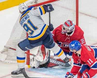 Montreal Canadiens goaltender Sam Montembeault (35) makes a pad save against St. Louis Blues right wing Vladimir Tarasenko (91) with Canadiens right wing Brendan Gallagher (11) looking on during second period in Montreal on Thursday, Feb. 17, 2022.