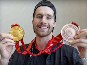 Canadian Olympic snowboarder Max Parrot shows off the gold and bronze medals he won at the Winter Games in Beijing during a news conference in Montreal on Tuesday, February 22, 2022.