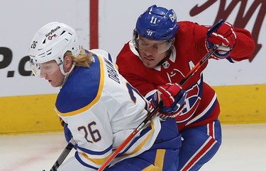 Montreal Canadiens' Brendan Gallagher (11) gets in close on Buffalo Sabres' Rasmus Dahlin (26) during first-period NHL action in Montreal on Wednesday, Feb. 23, 2022.