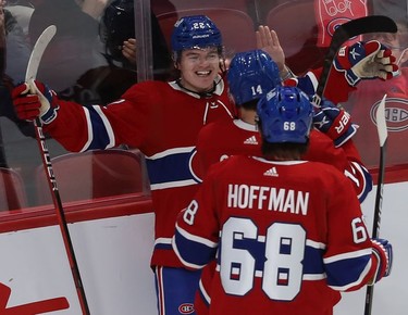Montreal Canadiens' Cole Caufield (22) celebrates his goal with teammates Nick Suzuki (14) and Mike Hoffman (68) against the Buffalo Sabres during third period NHL action in Montreal on Wednesday, Feb. 23, 2022.