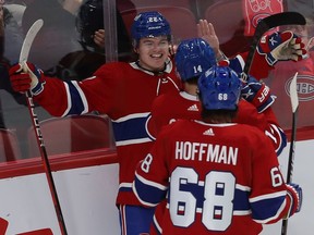 Montreal Canadiens' Cole Caufield (22) celebrates his goal with teammates Nick Suzuki (14) and Mike Hoffman against the Buffalo Sabres, during third period in Montreal on Feb. 23, 2022.