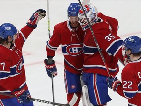 Montreal Canadiens goaltender Sam Montembeault celebrates his shutout against the Buffalo Sabres with teammates, Alexander Romanov (27), Brett Kulak (77) and Cole Caufield (22) on Feb. 23, 2022.