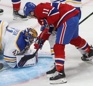 Montreal Canadiens' Brendan Gallagher (11) tries to dig for the puck covered by Buffalo Sabres goaltender Craig Anderson during first-period NHL action in Montreal on Wednesday, Feb. 23, 2022.